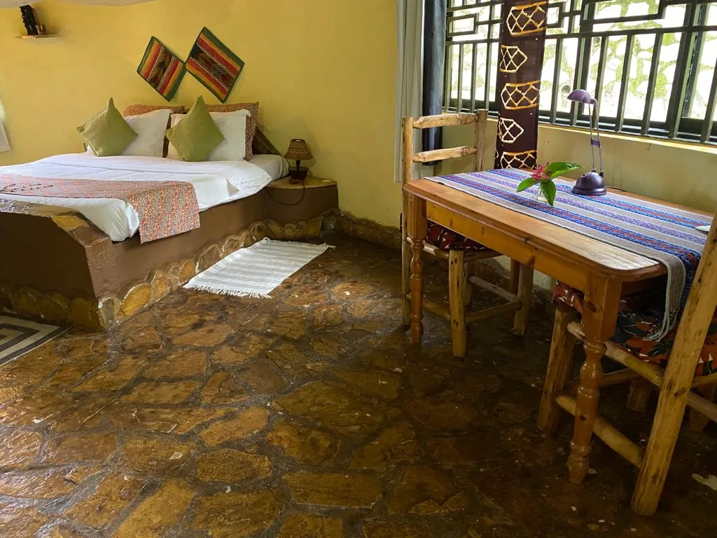 The Paw Paw Cottage bedroom with a king-size bed, writing desk and garden door.