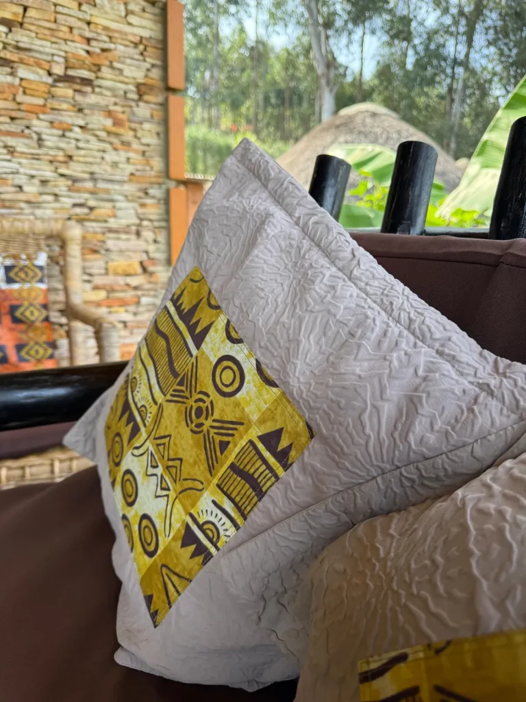 Geometric patterned cushions beside Nyore’s stone wall and timber veranda.